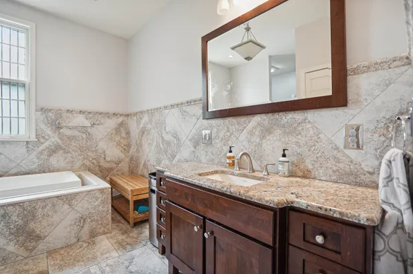 a bathroom with a granite countertop sink and a mirror