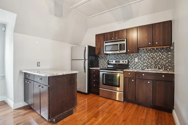 a kitchen with stainless steel appliances granite countertop a stove microwave and refrigerator