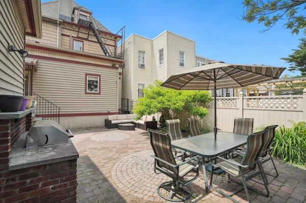 a view of a patio with table and chairs under an umbrella