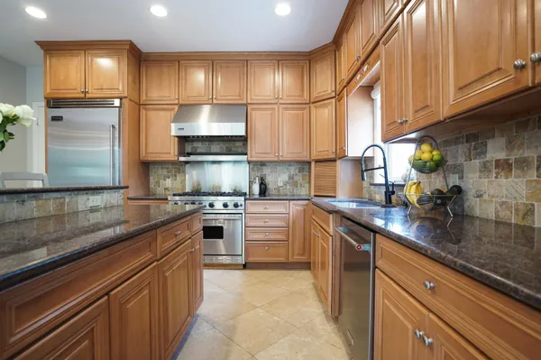 a kitchen with stainless steel appliances granite countertop a sink stove and cabinets