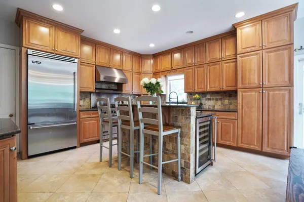 a kitchen with stainless steel appliances kitchen island granite countertop a refrigerator and cabinets