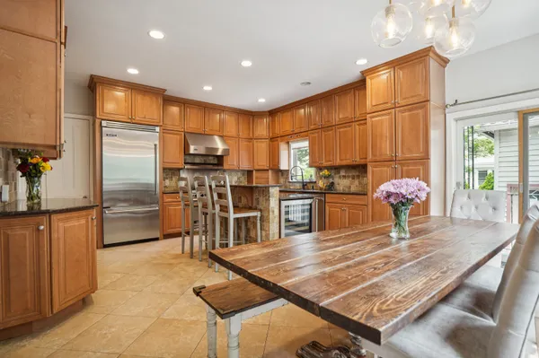a kitchen with stainless steel appliances kitchen island granite countertop a refrigerator and a sink