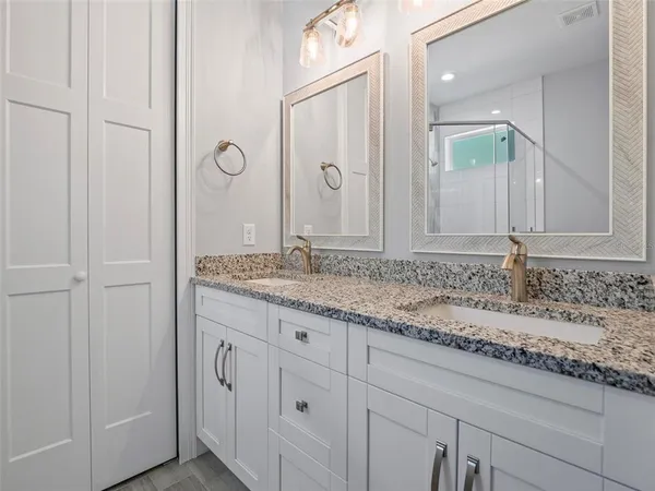 a bathroom with a granite countertop sink and a mirror