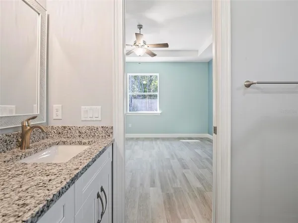 a bathroom with a granite countertop sink a vanity and mirror