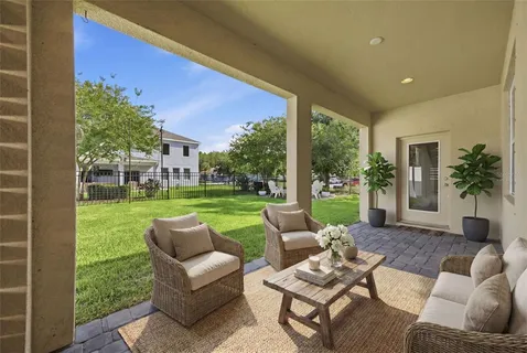 a view of a patio with couches chairs and a big yard