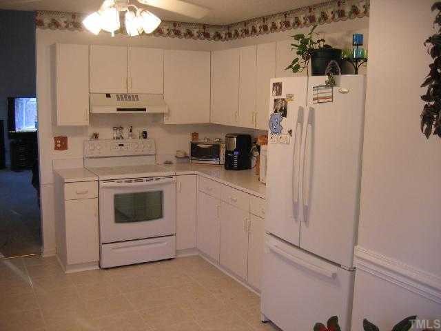 11801 North Exeter Way Raleigh, NC 27613 - Photo 5 of 12 a kitchen with cabinets and white appliances