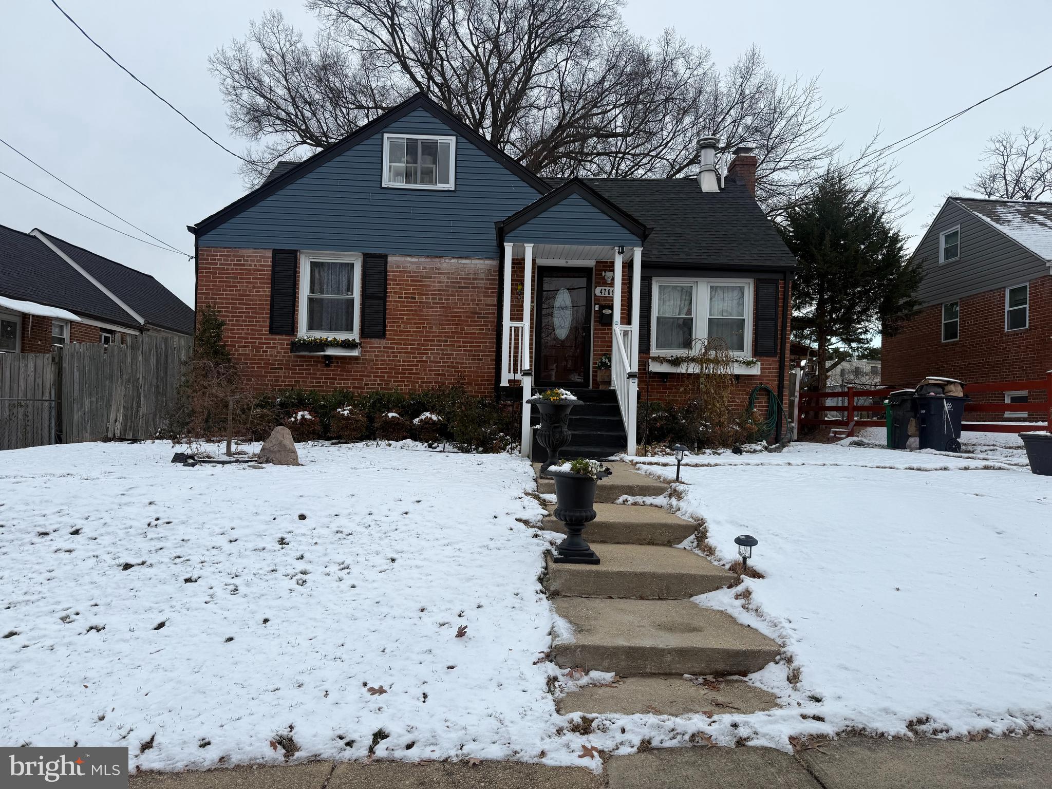a front view of a house with a yard covered with snow