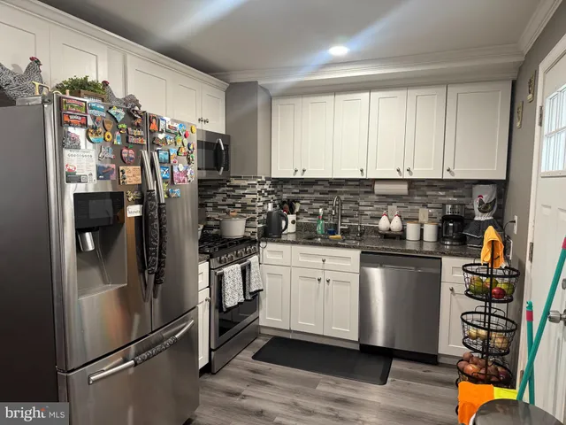 a kitchen with stainless steel appliances granite countertop a refrigerator and a stove top oven