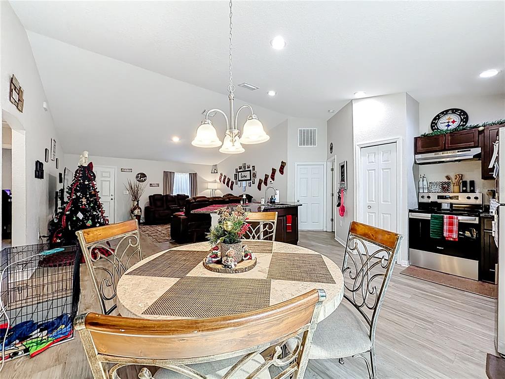 6188 East Seneca Street Inverness, FL 34452 - Photo 12 of 32 a dining room with furniture a chandelier and kitchen view