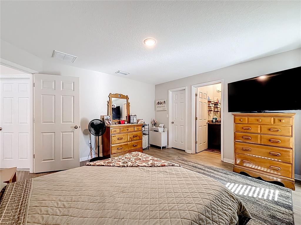 6188 East Seneca Street Inverness, FL 34452 - Photo 24 of 32 a bedroom with furniture and a flat screen tv