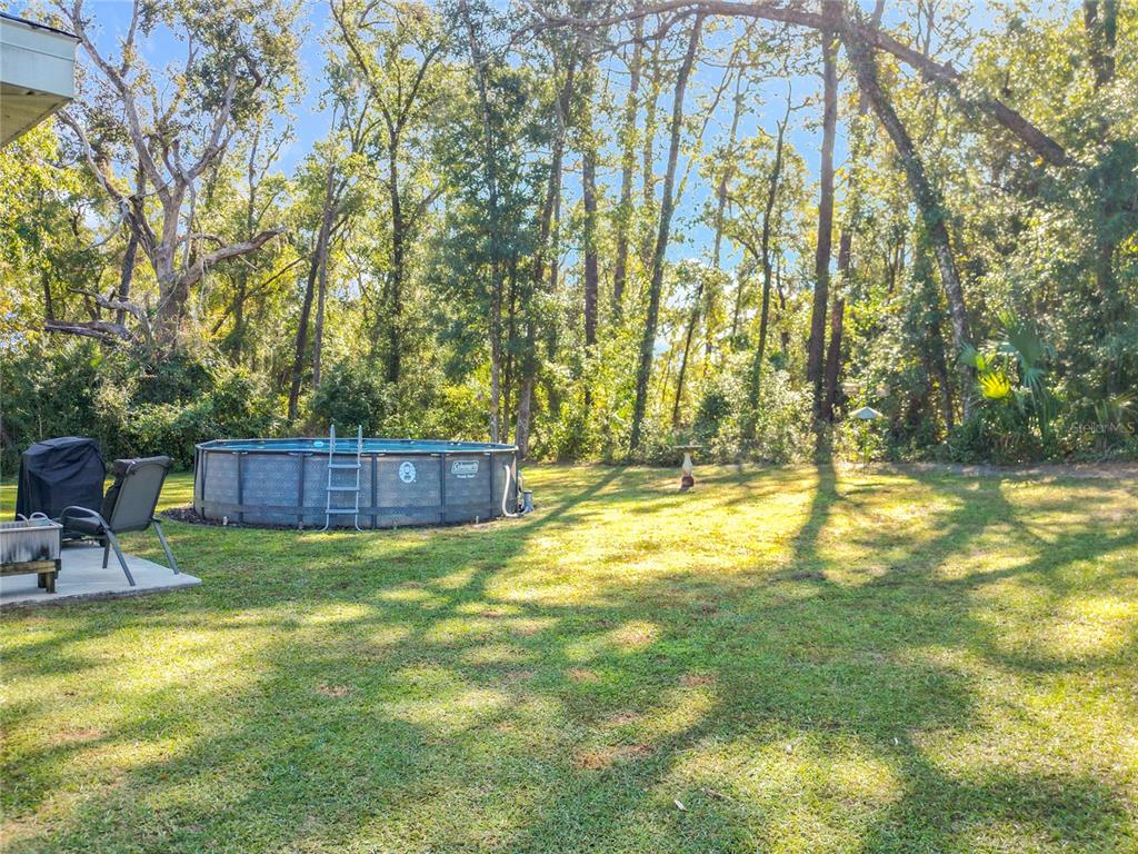 6188 East Seneca Street Inverness, FL 34452 - Photo 28 of 32 a view of swimming pool with lawn chairs and wooden fence