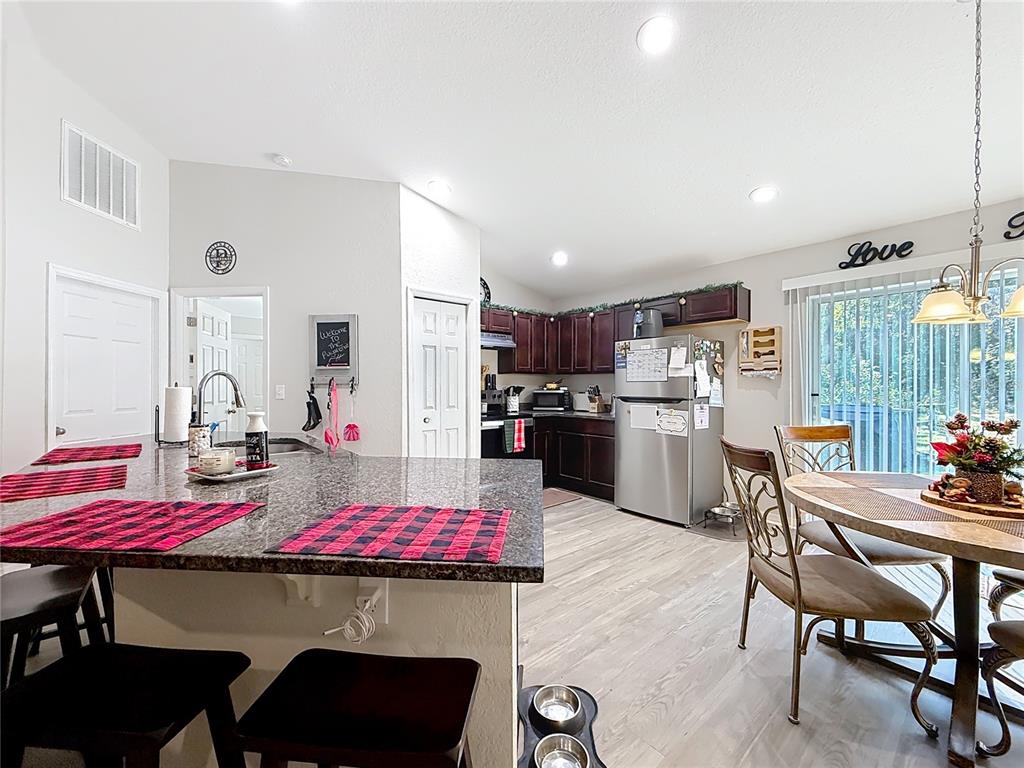 6188 East Seneca Street Inverness, FL 34452 - Photo 7 of 32 a kitchen with a dining table chairs and refrigerator