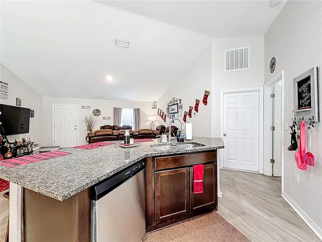 a kitchen with granite countertop a sink stove and cabinets