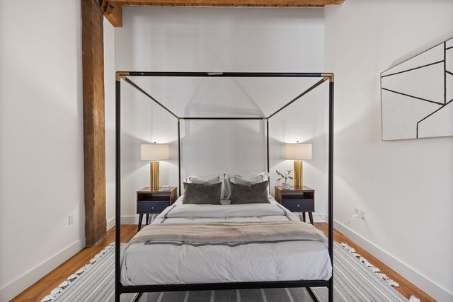 a bedroom with a bed and wooden floor