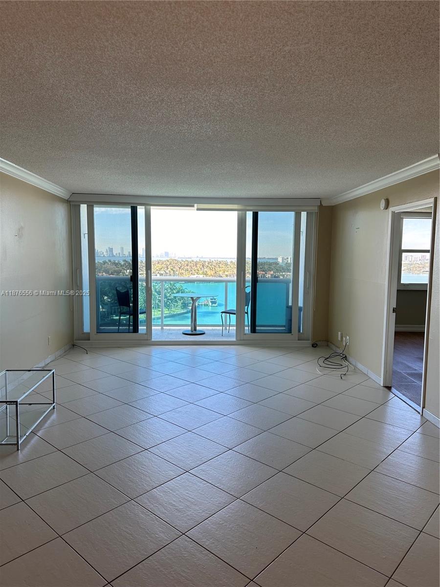 6770 Indian Creek Drive, Unit 11M Miami Beach, FL 33141 - Photo 2 of 10 an empty room with floor to ceiling windows and an outdoor view