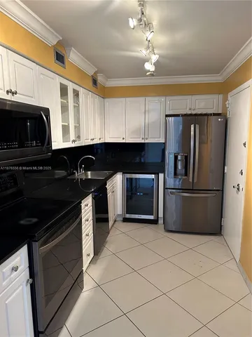 a kitchen with cabinets a sink and stainless steel appliances