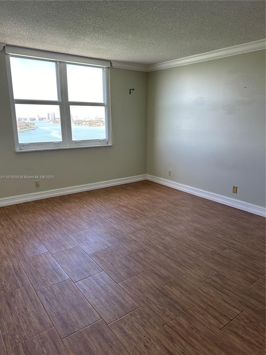 6770 Indian Creek Drive, Unit 11M Miami Beach, FL 33141 - Photo 7 of 10 an empty room with wooden floor and windows