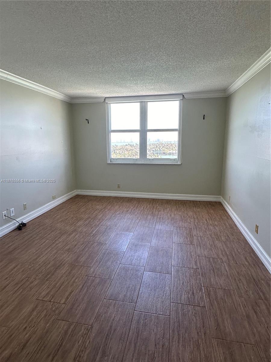 6770 Indian Creek Drive, Unit 11M Miami Beach, FL 33141 - Photo 8 of 10 an empty room with wooden floor and windows