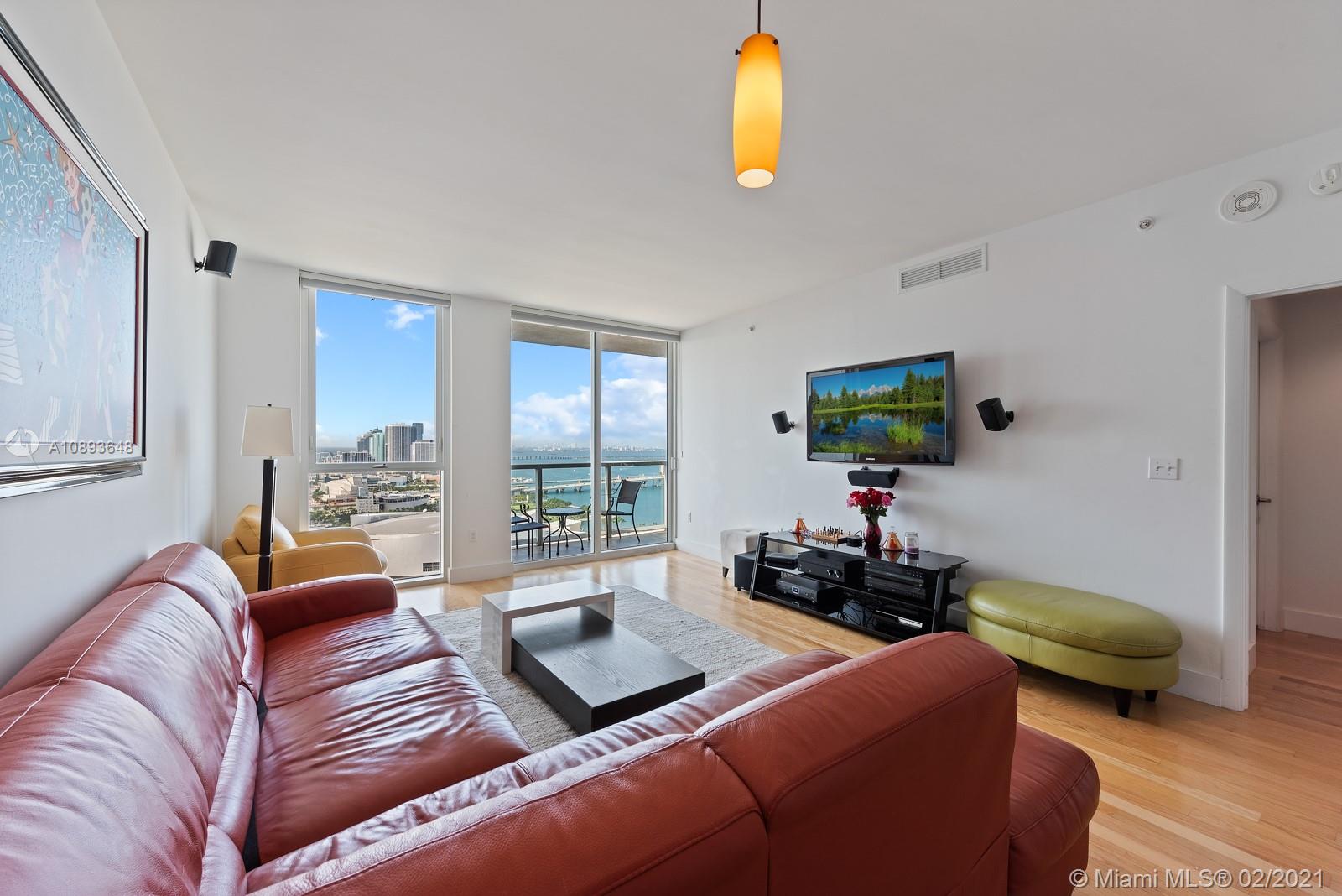 244 Biscayne Boulevard, Unit 3406 Miami, FL 33132 - Photo 3 of 20 a living room with furniture and a flat screen tv
