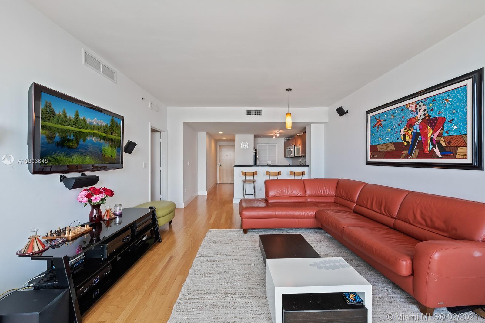 244 Biscayne Boulevard, Unit 3406 Miami, FL 33132 - Photo 4 of 20 a living room with furniture and a flat screen tv