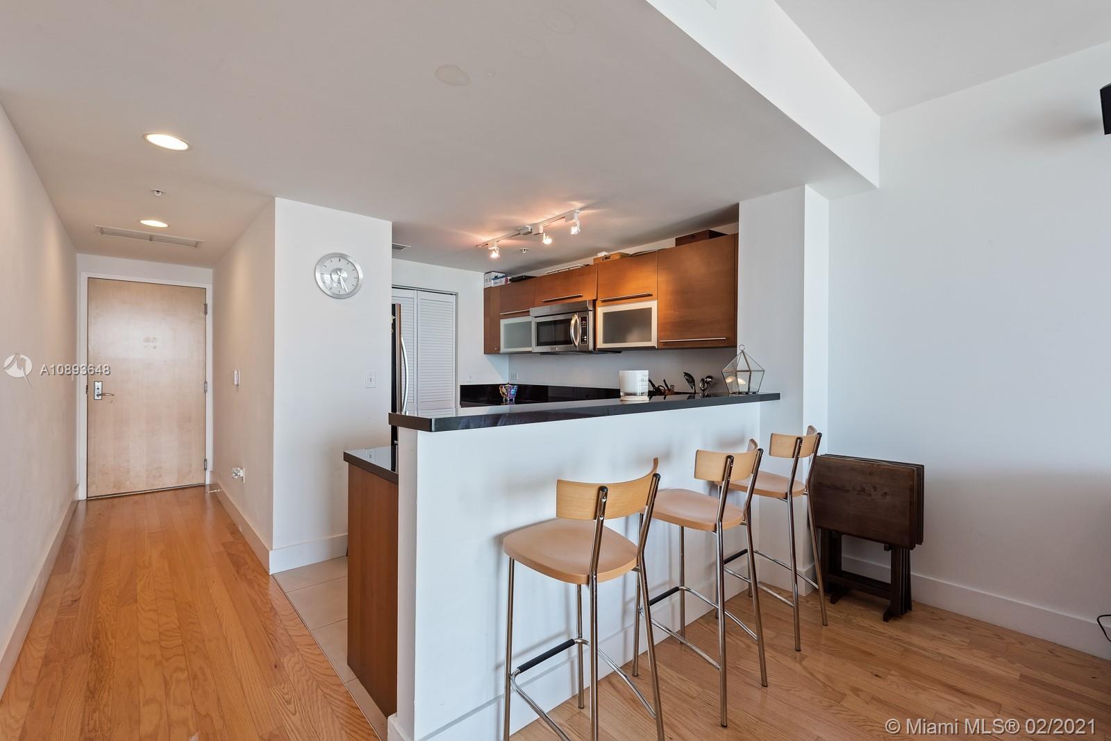 244 Biscayne Boulevard, Unit 3406 Miami, FL 33132 - Photo 5 of 20 a view of a dining room with furniture and wooden floor