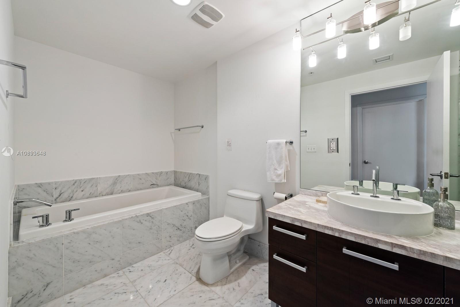244 Biscayne Boulevard, Unit 3406 Miami, FL 33132 - Photo 9 of 20 a bathroom with a sink a toilet and a large mirror