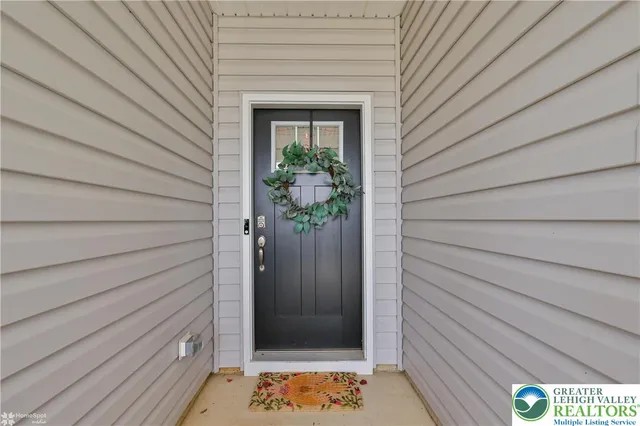 a living room with stainless steel appliances furniture a fireplace a flat screen tv and a window