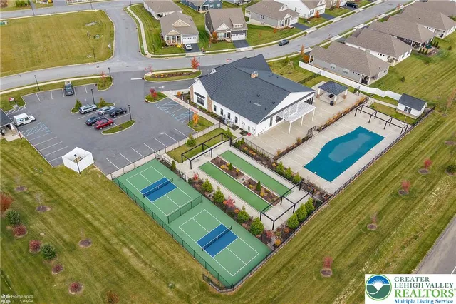 a kitchen with stainless steel appliances granite countertop a stove top oven a sink a refrigerator and white cabinets with wooden floor