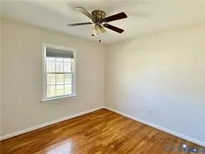 an empty room with a window and a ceiling fan