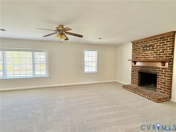 an empty room with windows and fireplace