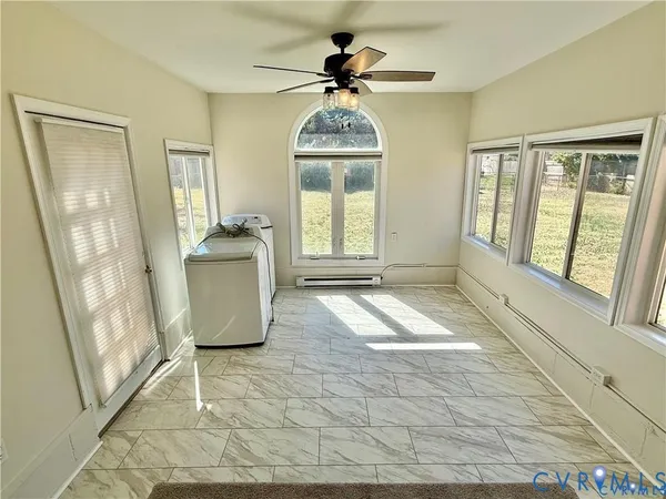 a living room with a floor to ceiling window and a rug