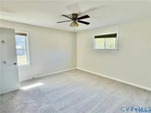an empty room with a ceiling fan and a window
