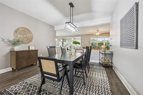 a kitchen with stainless steel appliances kitchen island granite countertop a stove a sink and white cabinets with wooden floor