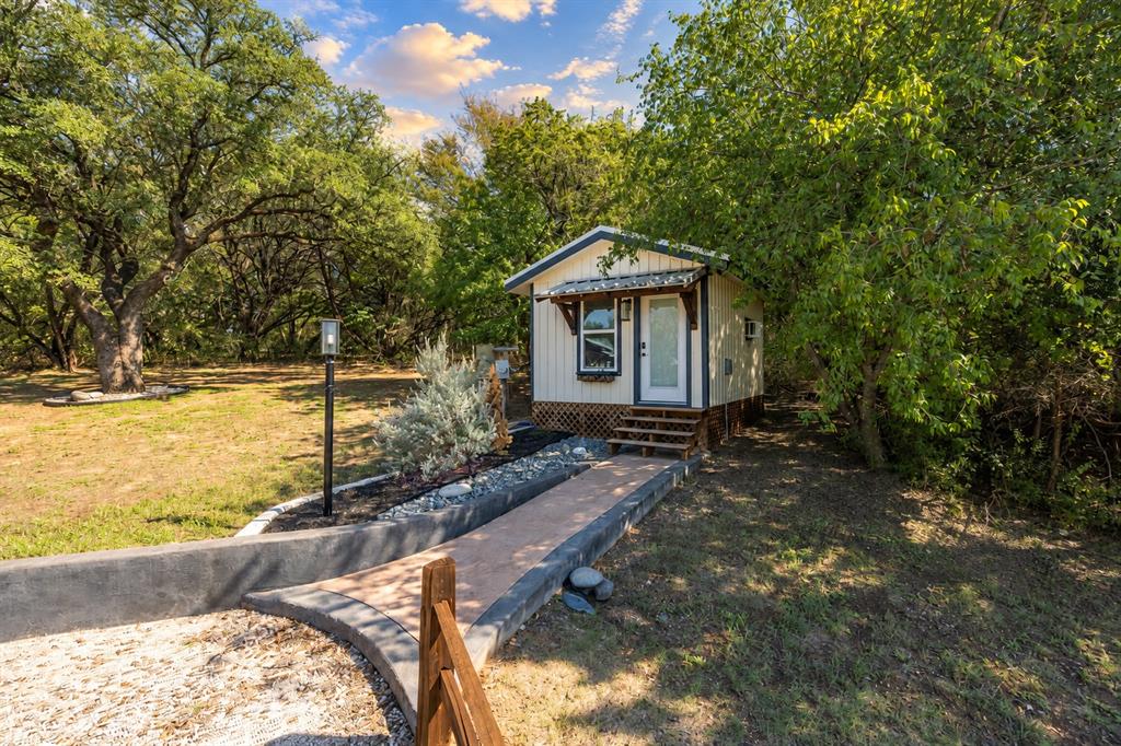 384 Ft Graham Road Waco, TX 76705 - Photo 29 of 36 Compact dwelling with a white facade, covered entry, and multi-level wood steps
