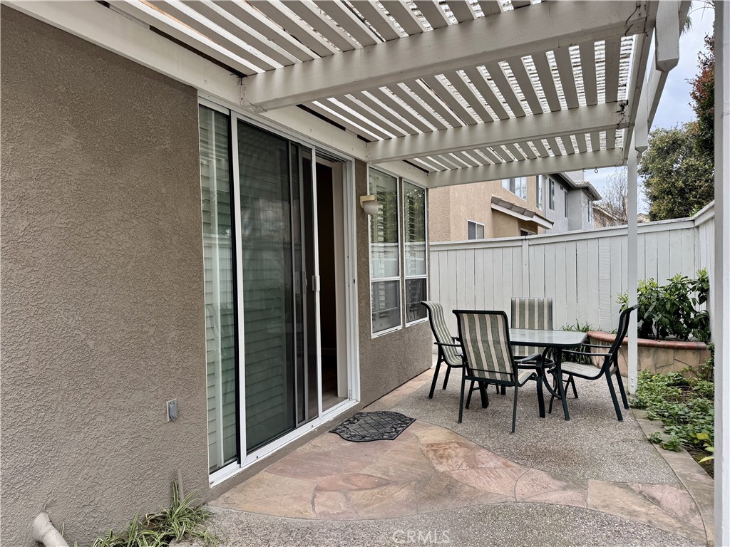 62 Northern Pine Loop Aliso Viejo, CA 92656 - Photo 27 of 27 a view of a patio with table and chairs with wooden fence and plants