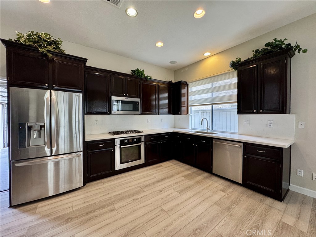 62 Northern Pine Loop Aliso Viejo, CA 92656 - Photo 6 of 27 a kitchen with stainless steel appliances kitchen island granite countertop a refrigerator stove top oven and sink