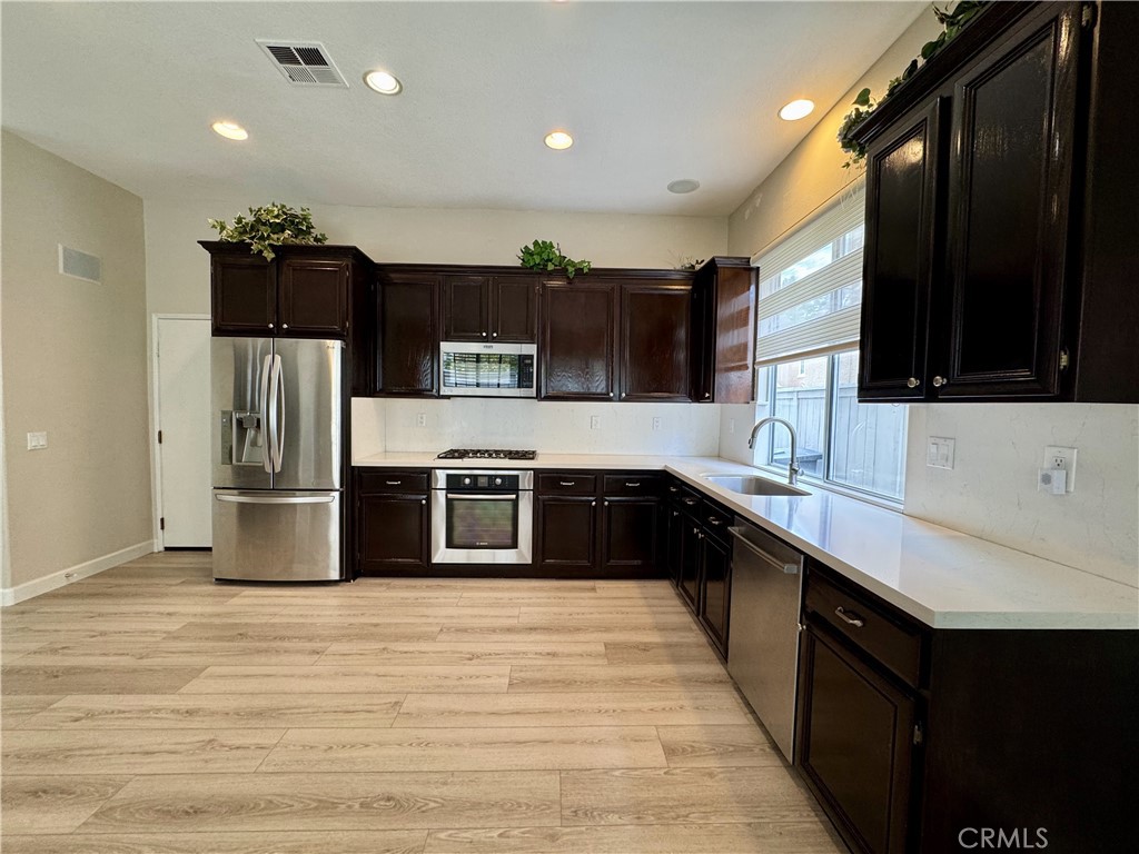 62 Northern Pine Loop Aliso Viejo, CA 92656 - Photo 8 of 27 a kitchen with stainless steel appliances wooden cabinets a sink and a stove