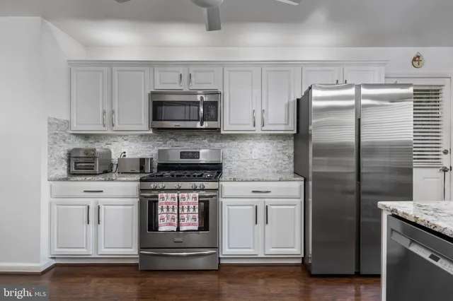 a kitchen with stainless steel appliances granite countertop a stove a refrigerator and a microwave