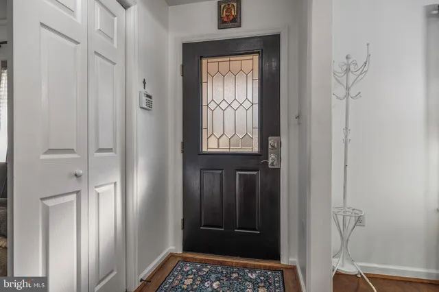 a view of a hallway with wooden floor and a door