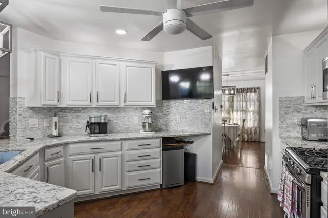 a kitchen with stainless steel appliances white cabinets a sink and a stove