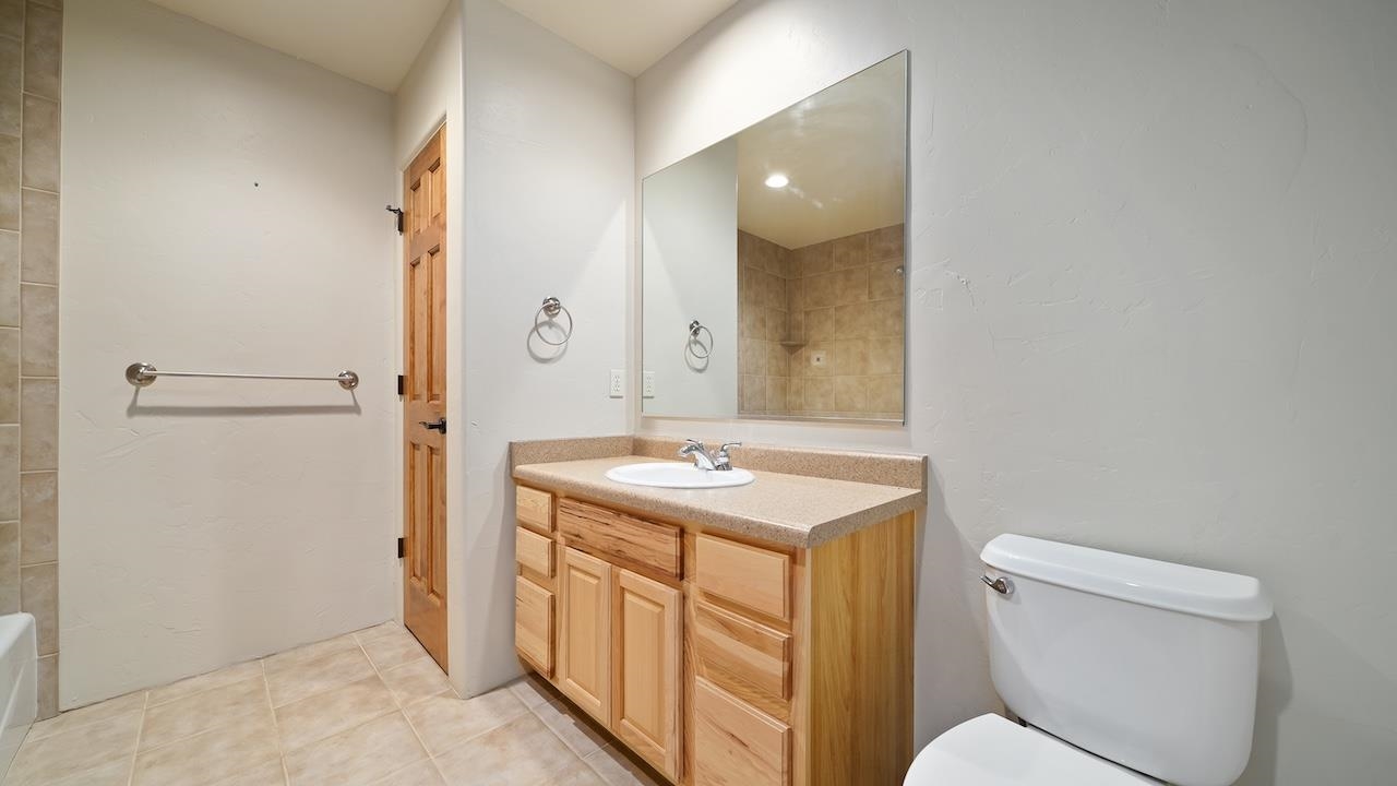 1296 Santa Fe Circle Fruita, CO 81521 - Photo 14 of 22 a bathroom with a granite countertop toilet a sink and a mirror