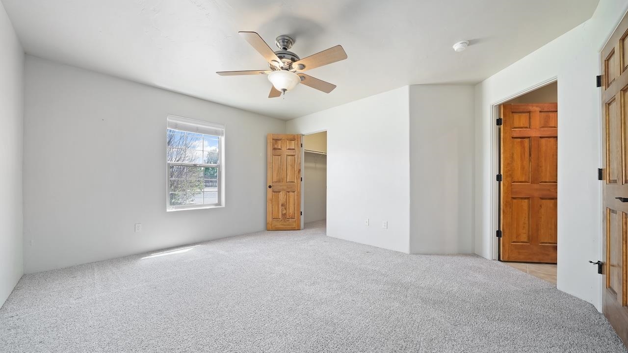 1296 Santa Fe Circle Fruita, CO 81521 - Photo 7 of 22 an empty room with windows and fan