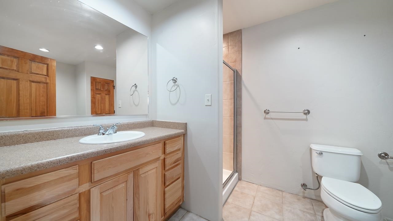 1296 Santa Fe Circle Fruita, CO 81521 - Photo 9 of 22 a bathroom with a granite countertop sink a toilet and a mirror