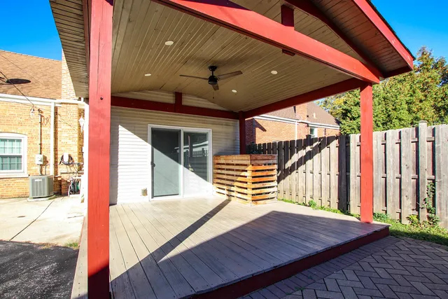 a balcony with wooden floor table and chairs