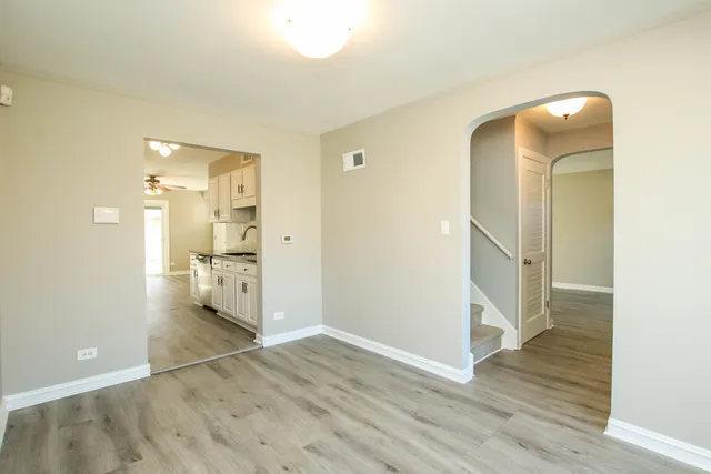 an empty room with wooden floor and bathroom