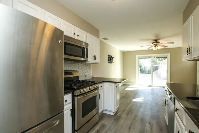 a kitchen with stainless steel appliances a stove microwave and sink