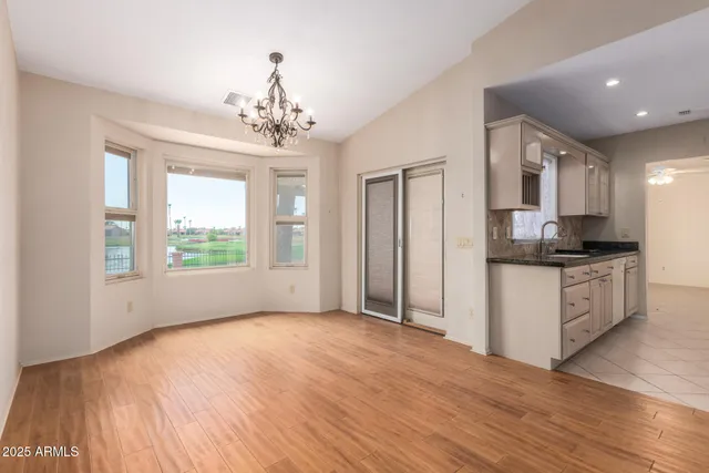 a view of kitchen with granite countertop cabinets and refrigerator