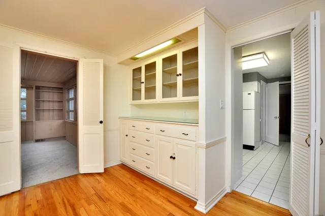 a kitchen with white cabinets and white refrigerator