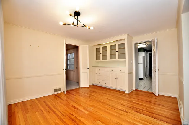 a kitchen with white cabinets and appliances