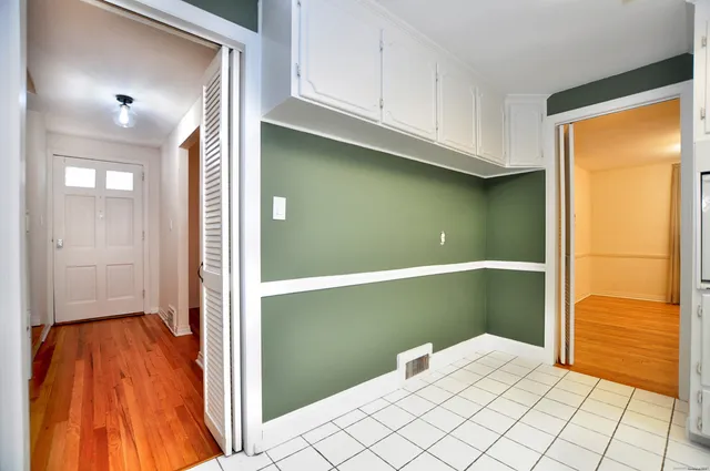 an empty room with cabinet and windows